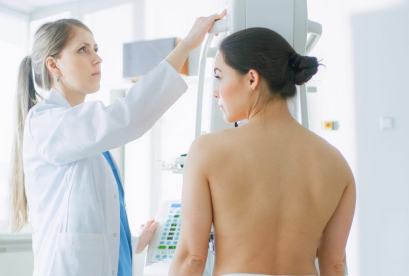 In the Hospital, Mammography Technologist / Doctor adjusts Mammogram Machine for a Female Patient. Modern Technologically Advanced Clinic with Professional Doctors. Breast Cancer Prevention Screening.